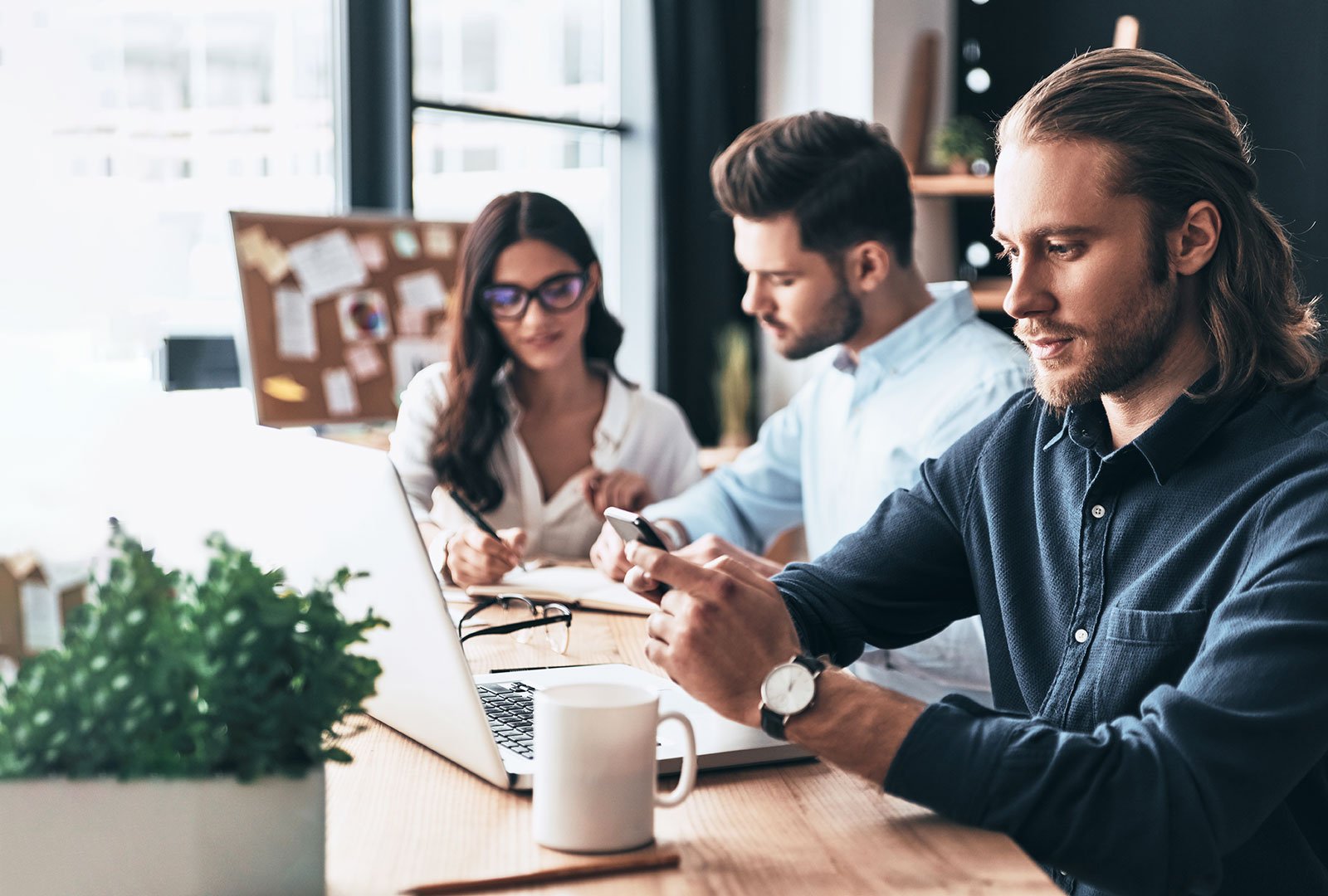 three people working at a desk