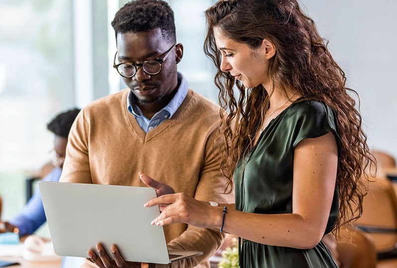 two people looking at a laptop