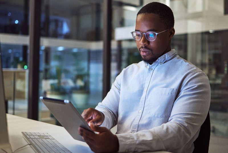 a man at his desk working on a tablet