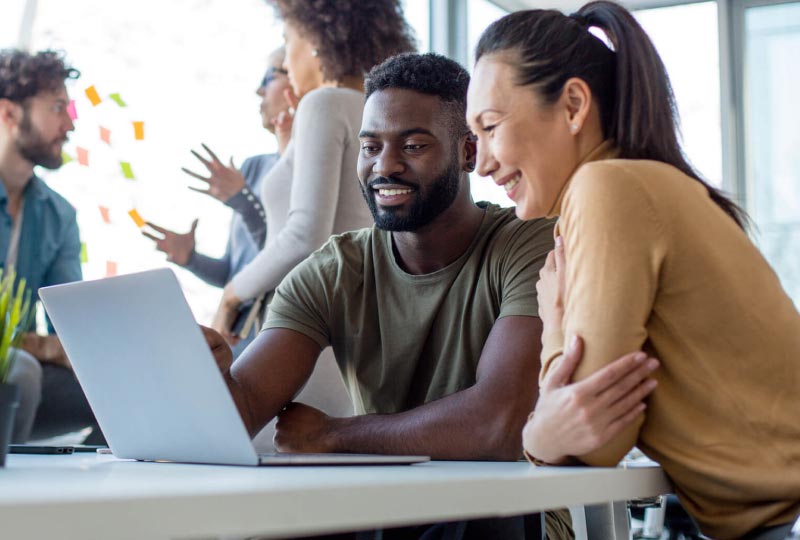 two people collaborating at a laptop