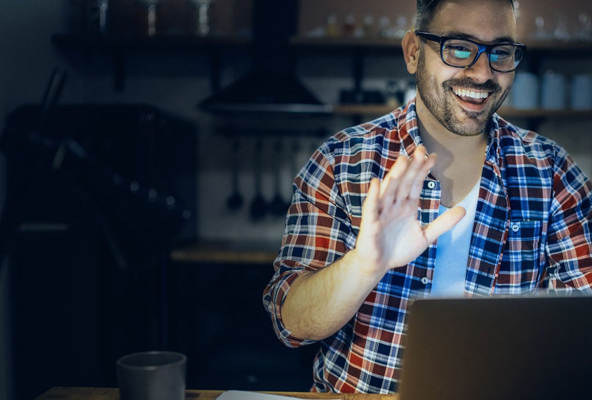 man waving at laptop