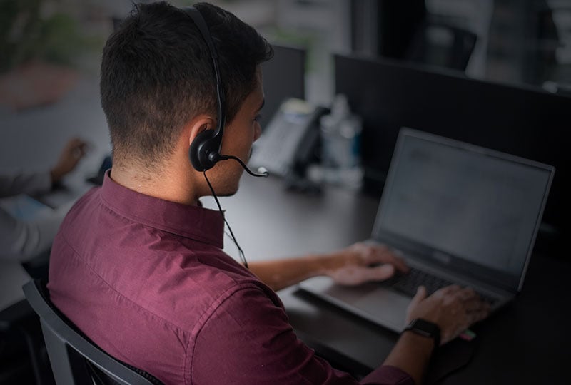 man at a computer with a headset