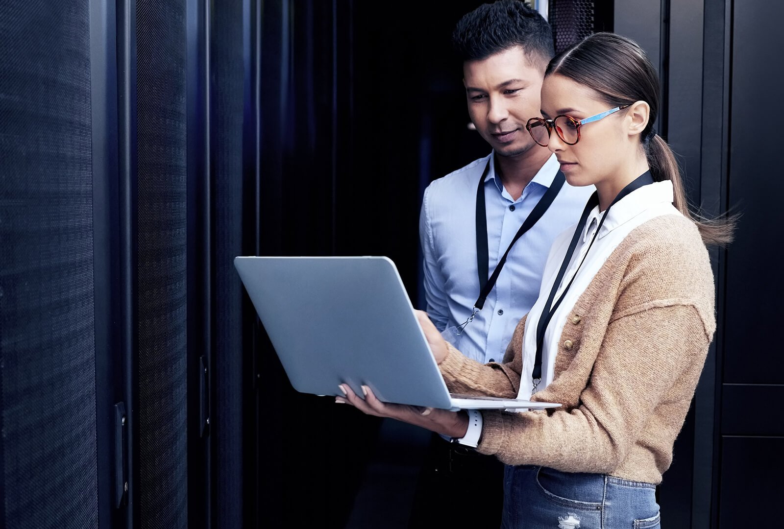 two coworkers in a tech. room looking at a computer